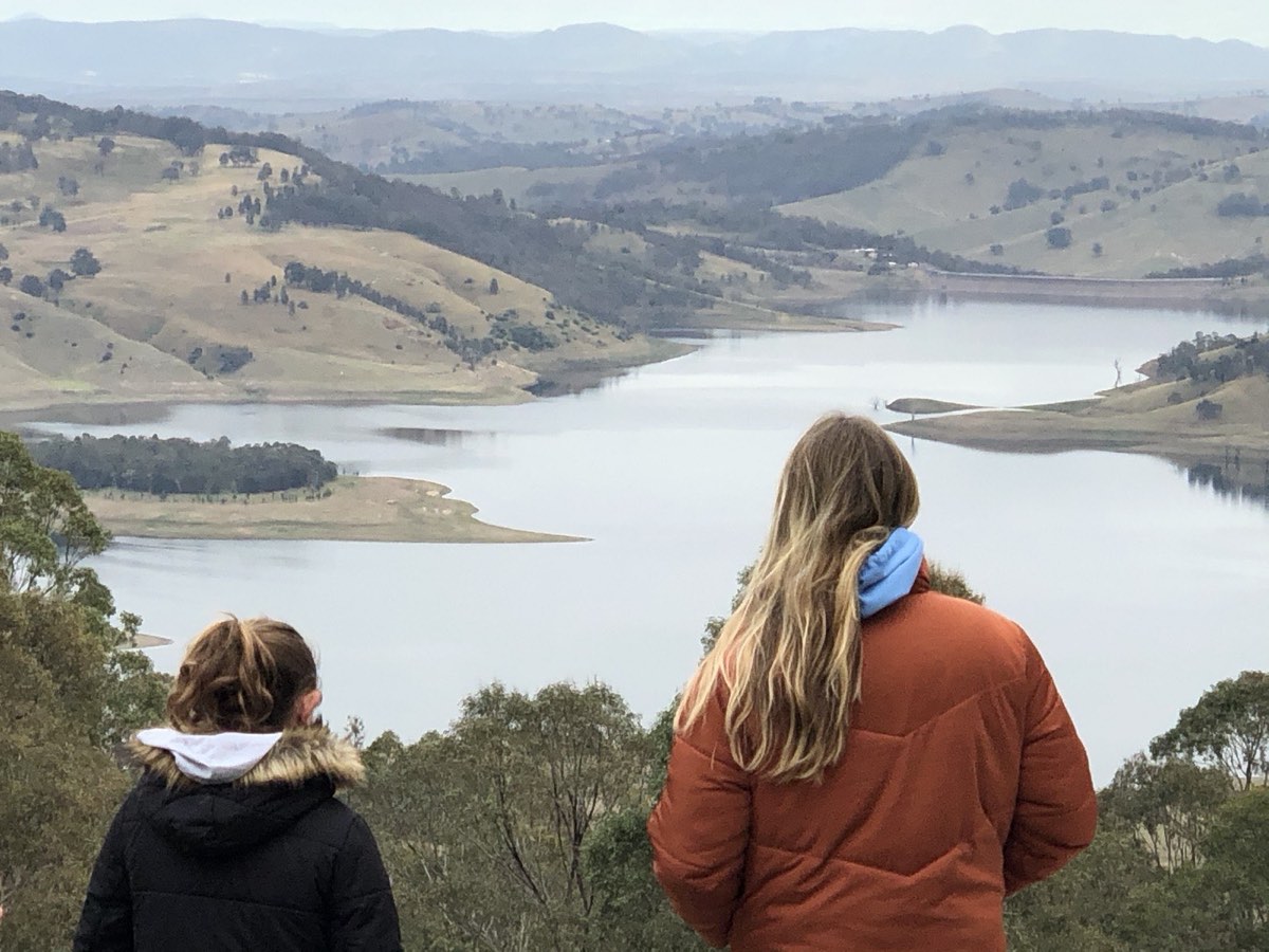 Two people looking out over the lake from a hilltop